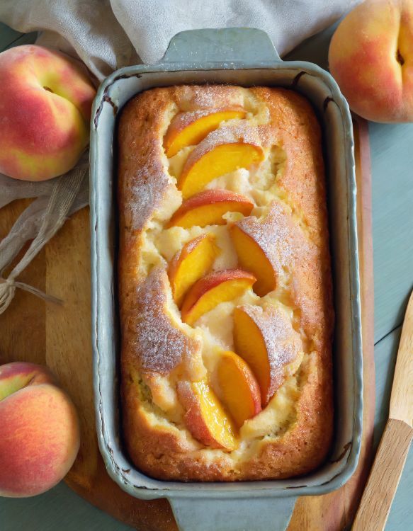 a cake in a pan with peaches on the side