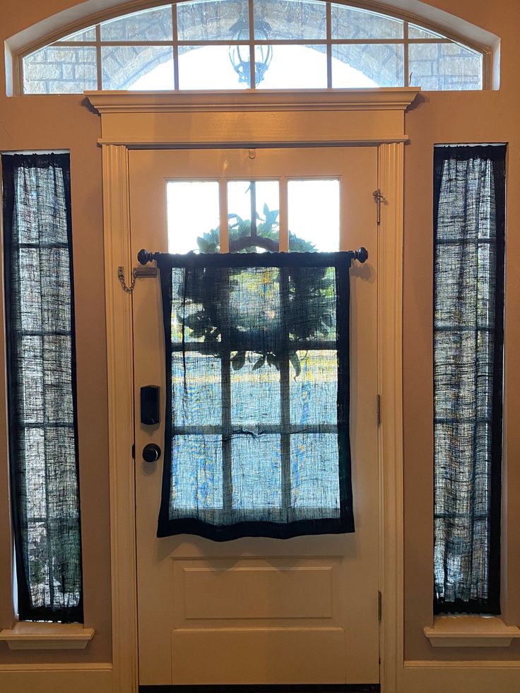 the front door is decorated with black and white curtains