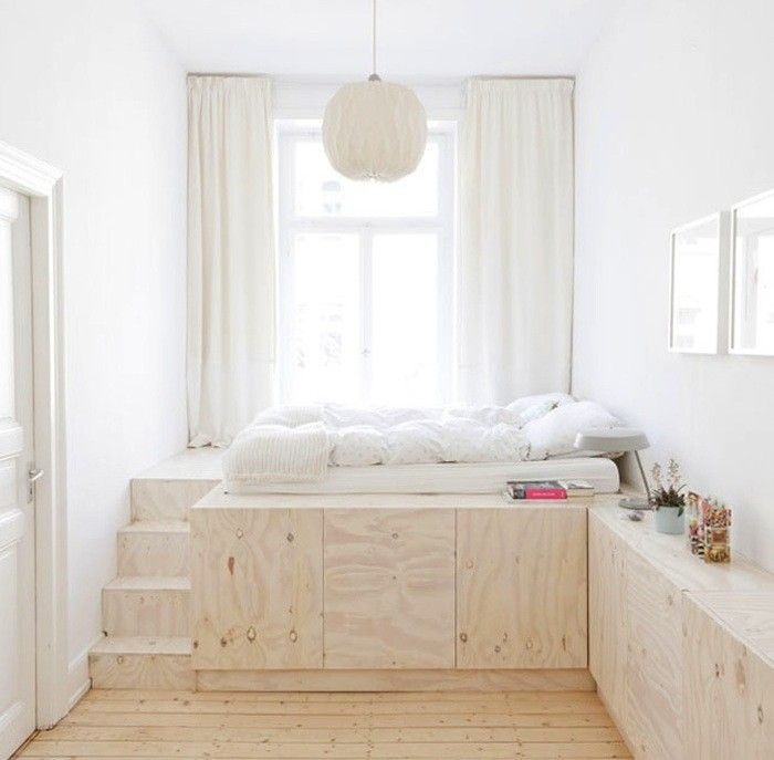 a bedroom with white walls and wooden floors