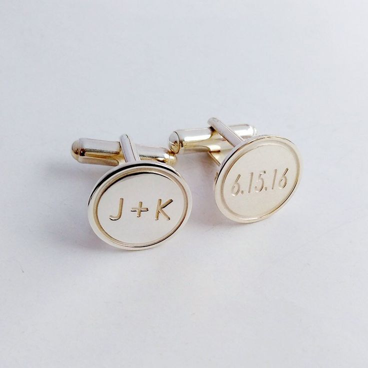 two gold cufflinks with initials and date engraved on the back, set against a plain white background