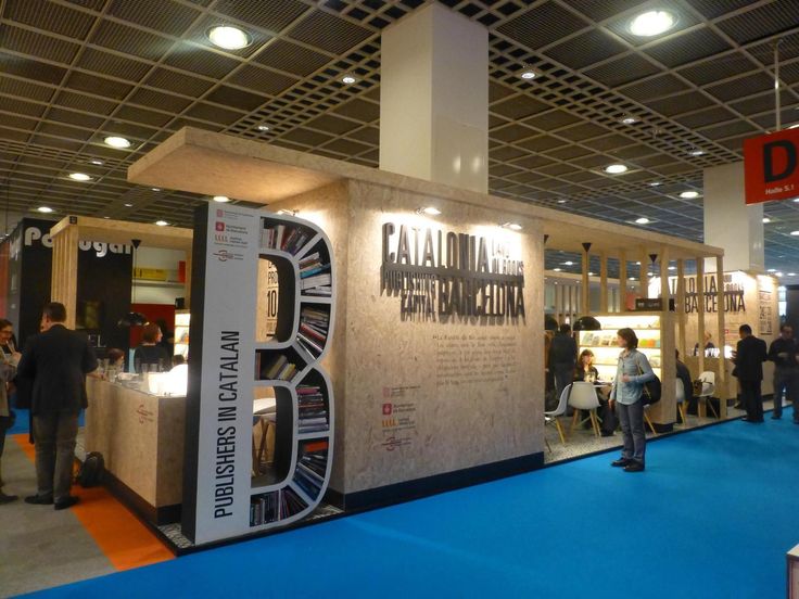 people are standing in front of a booth at a trade show that displays books and magazines