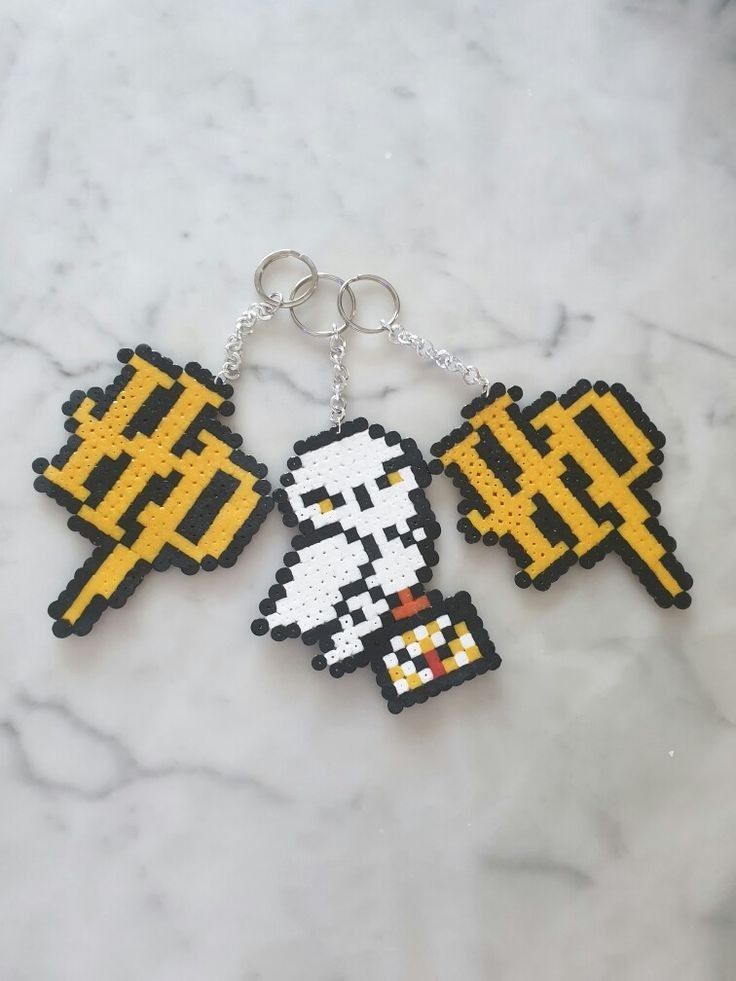 two pixel keychains that have been made to look like video games characters on them