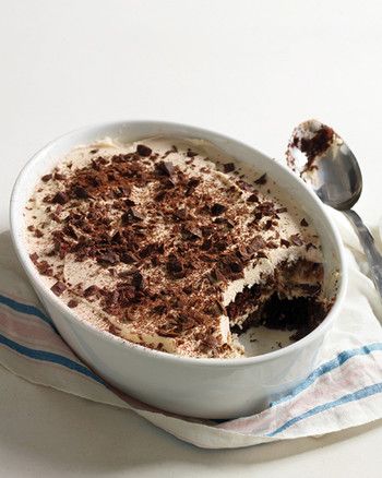 there is a cake in the bowl with chocolate shavings on it and a spoon next to it