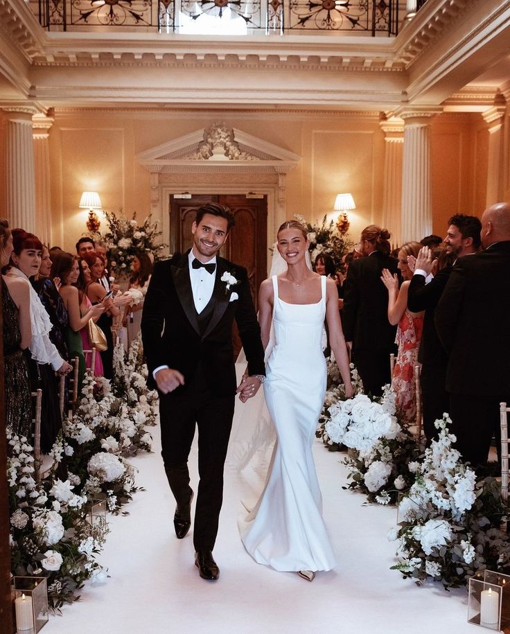 a man and woman are walking down the aisle