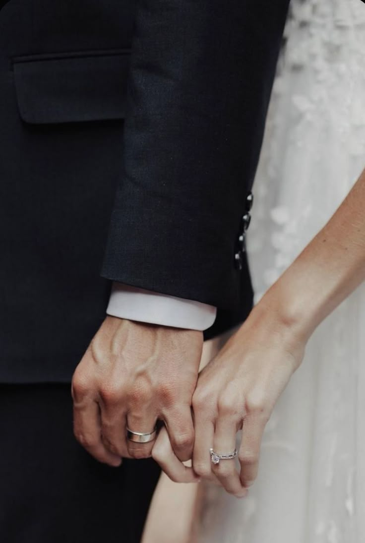 a close up of two people holding hands