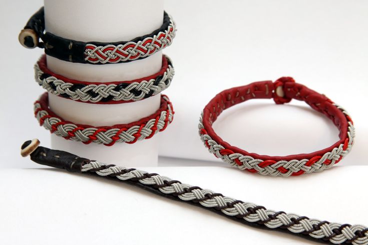 four different bracelets are stacked on top of each other and one has a hook