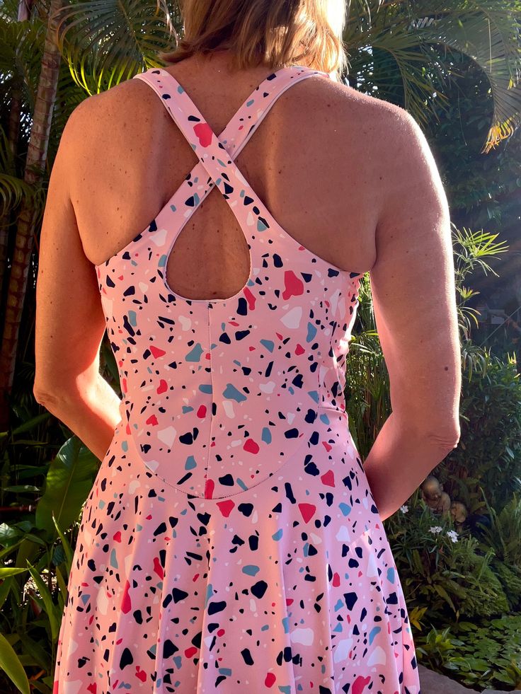 the back of a woman's pink dress with hearts on it and an open neckline