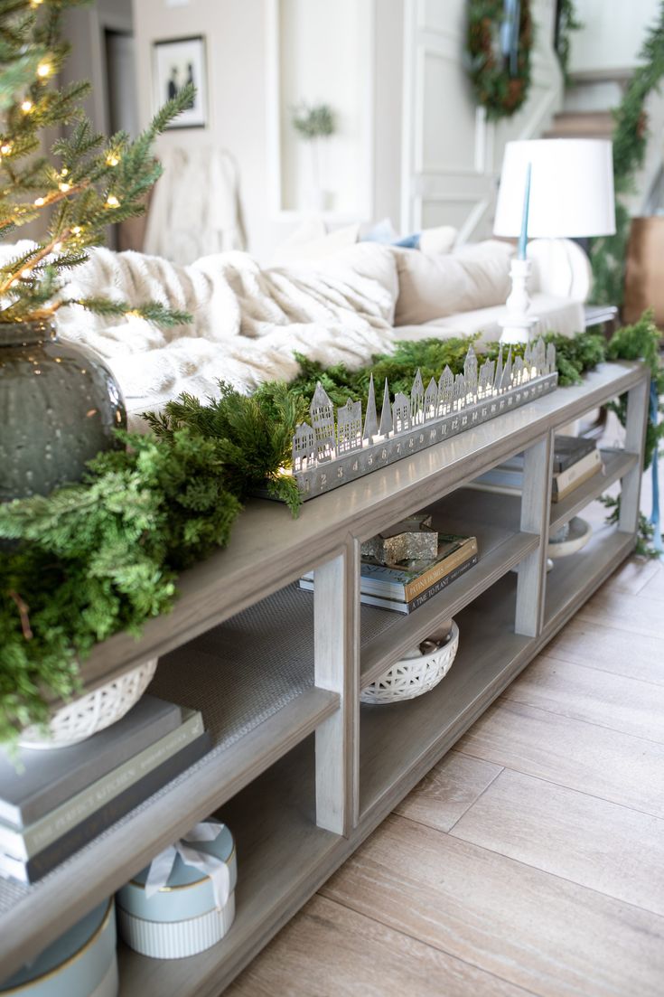 a living room filled with lots of furniture and christmas decorations on top of a table