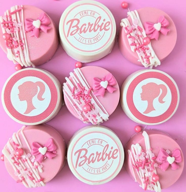 some pink and white cupcakes with bows on them