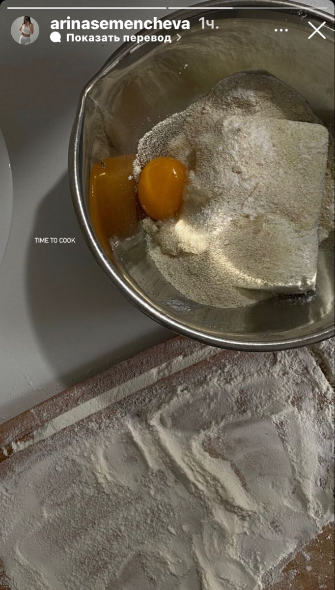 an egg is being added to flour in a bowl