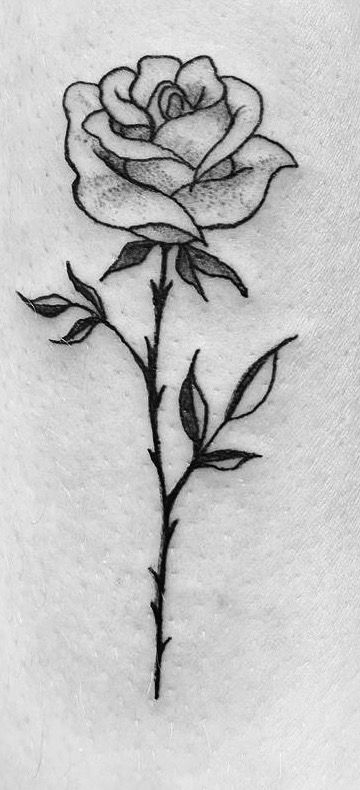 a black and white photo of a rose tattoo