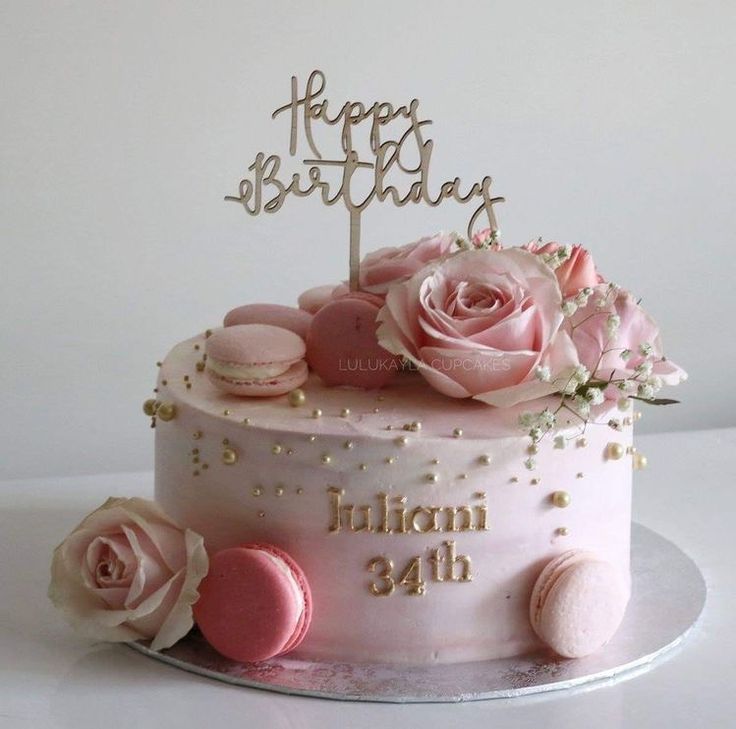 a birthday cake with pink frosting and flowers