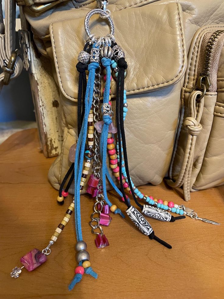 a handbag with several different colored beads hanging from it