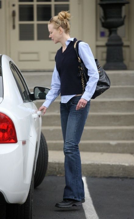 a woman standing next to a white car with her hand in the back door pocket