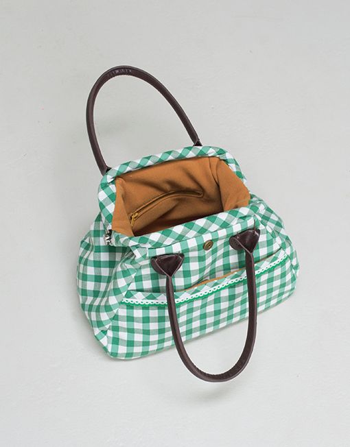 a green and white checkered purse with a brown handle