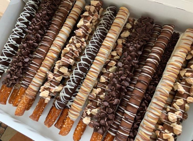 there are many different kinds of donuts in the box on this table, including one with chocolate and caramel