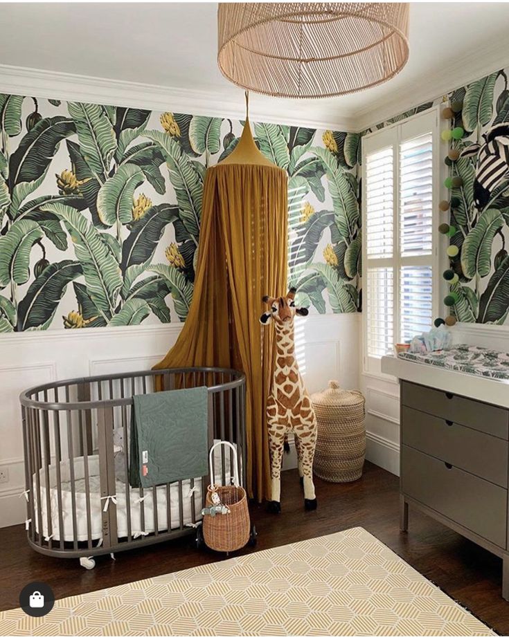 a baby's room with a giraffe and zebra wallpaper