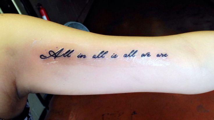 a person with a tattoo on their arm that says, all in all we do is one