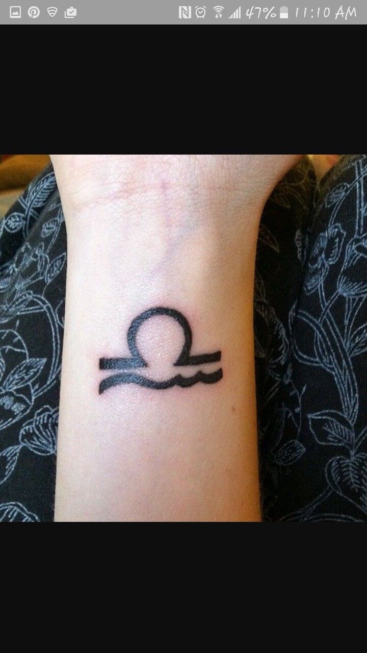 a woman's wrist with a tattoo on it that has an image of the zodiac sign