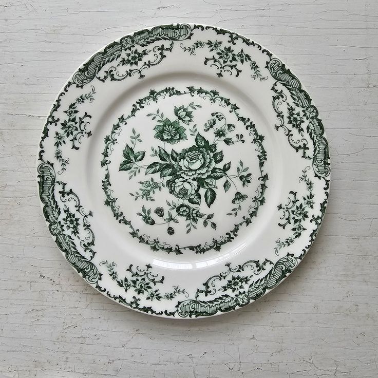 a green and white plate sitting on top of a wooden table next to a wall