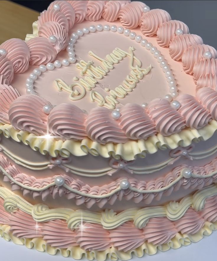 a pink and white heart shaped cake on a table