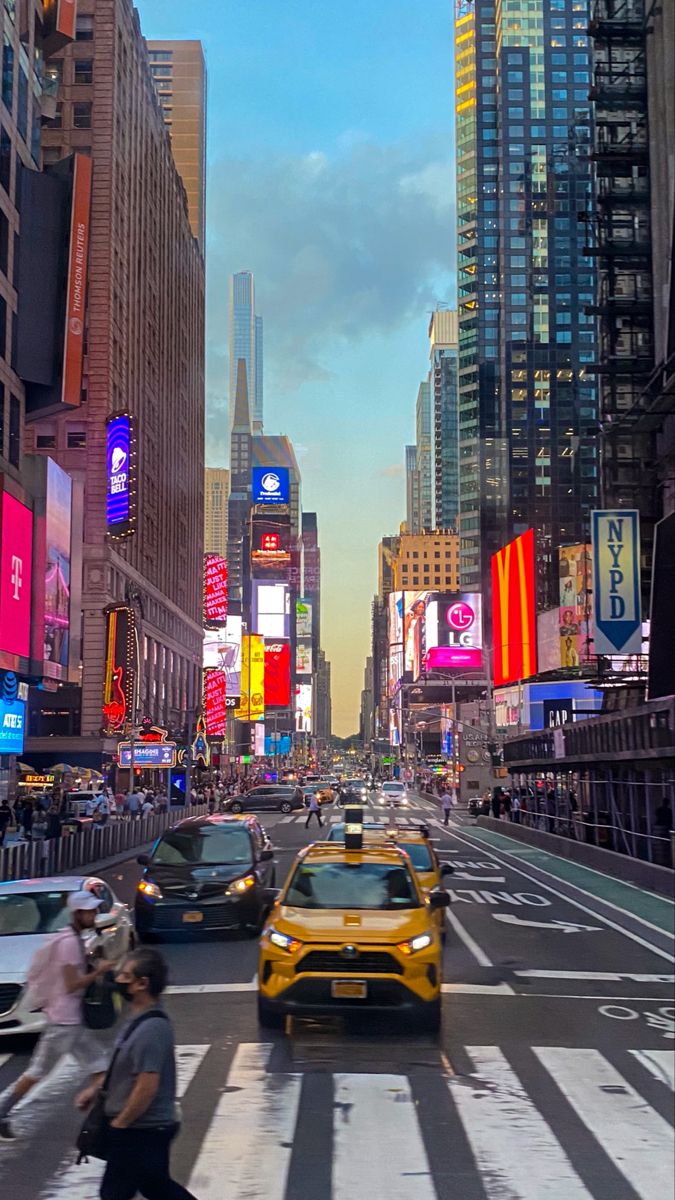 a busy city street filled with lots of traffic and people walking on the side of it