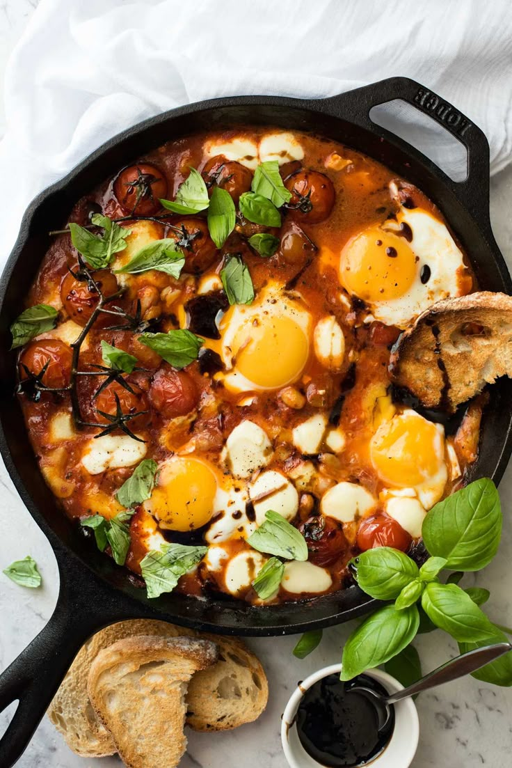 an iron skillet filled with eggs and tomato sauce