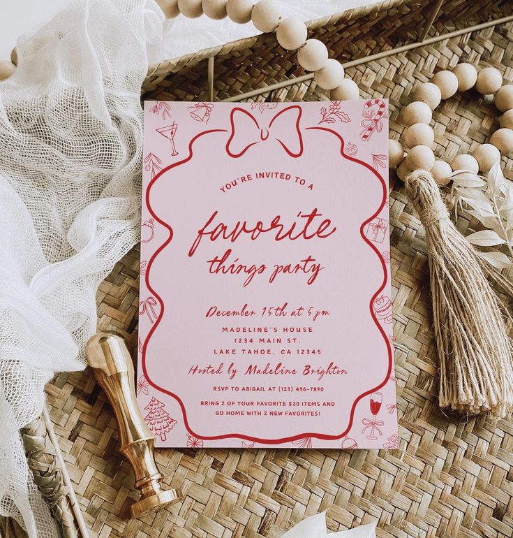 a pink and red party card sitting on top of a wicker basket next to tassels