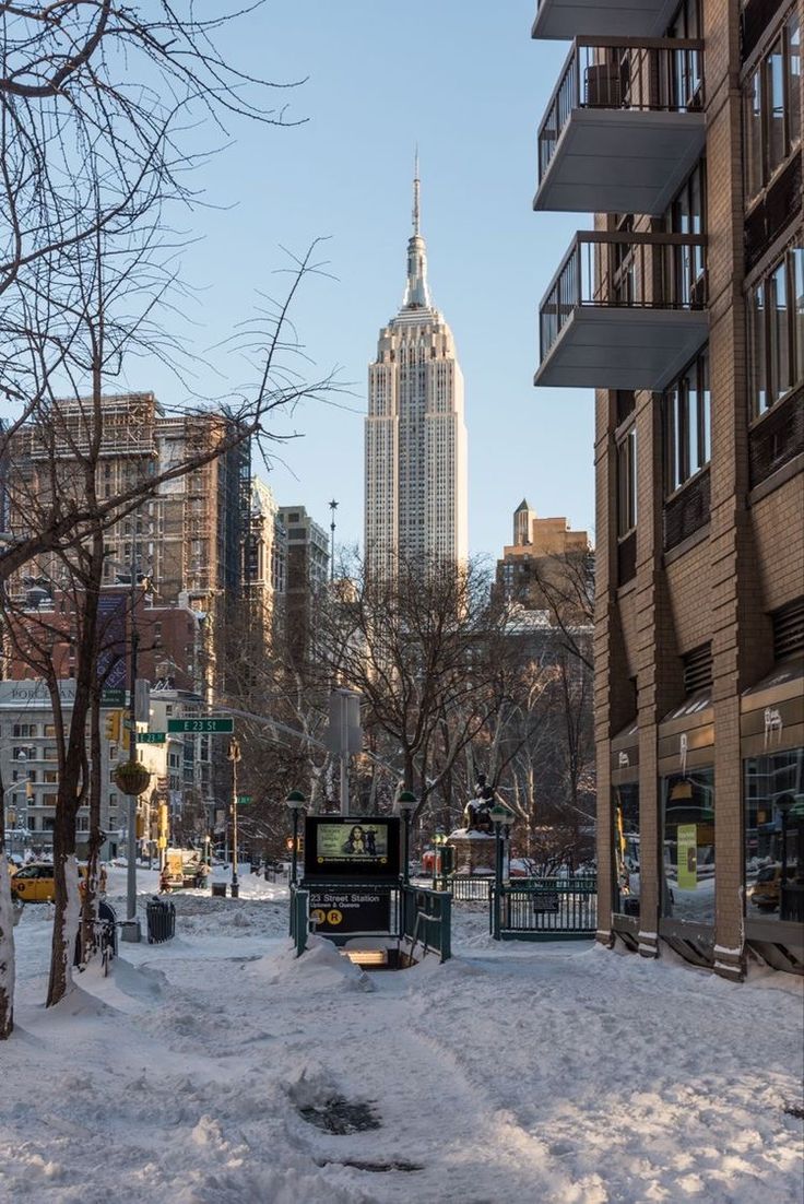 a city street covered in snow with tall buildings