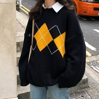 a woman is standing on the sidewalk wearing a black sweater with yellow and white squares