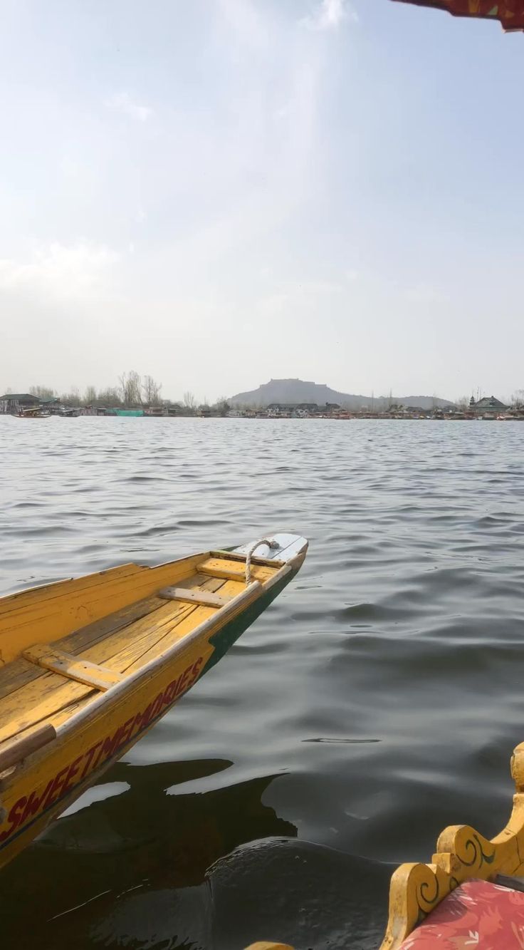 a yellow boat floating on top of a large body of water