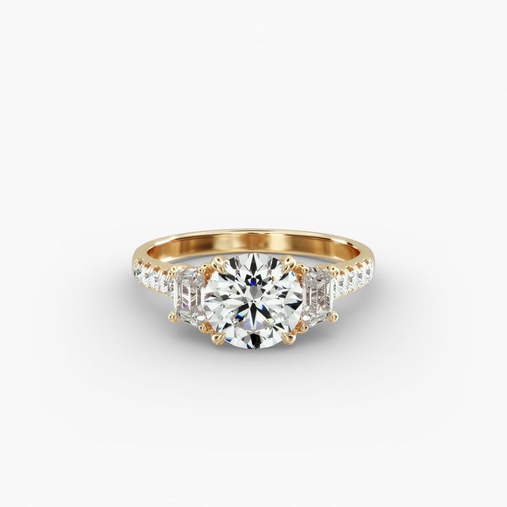 a gold engagement ring with three stones on the side