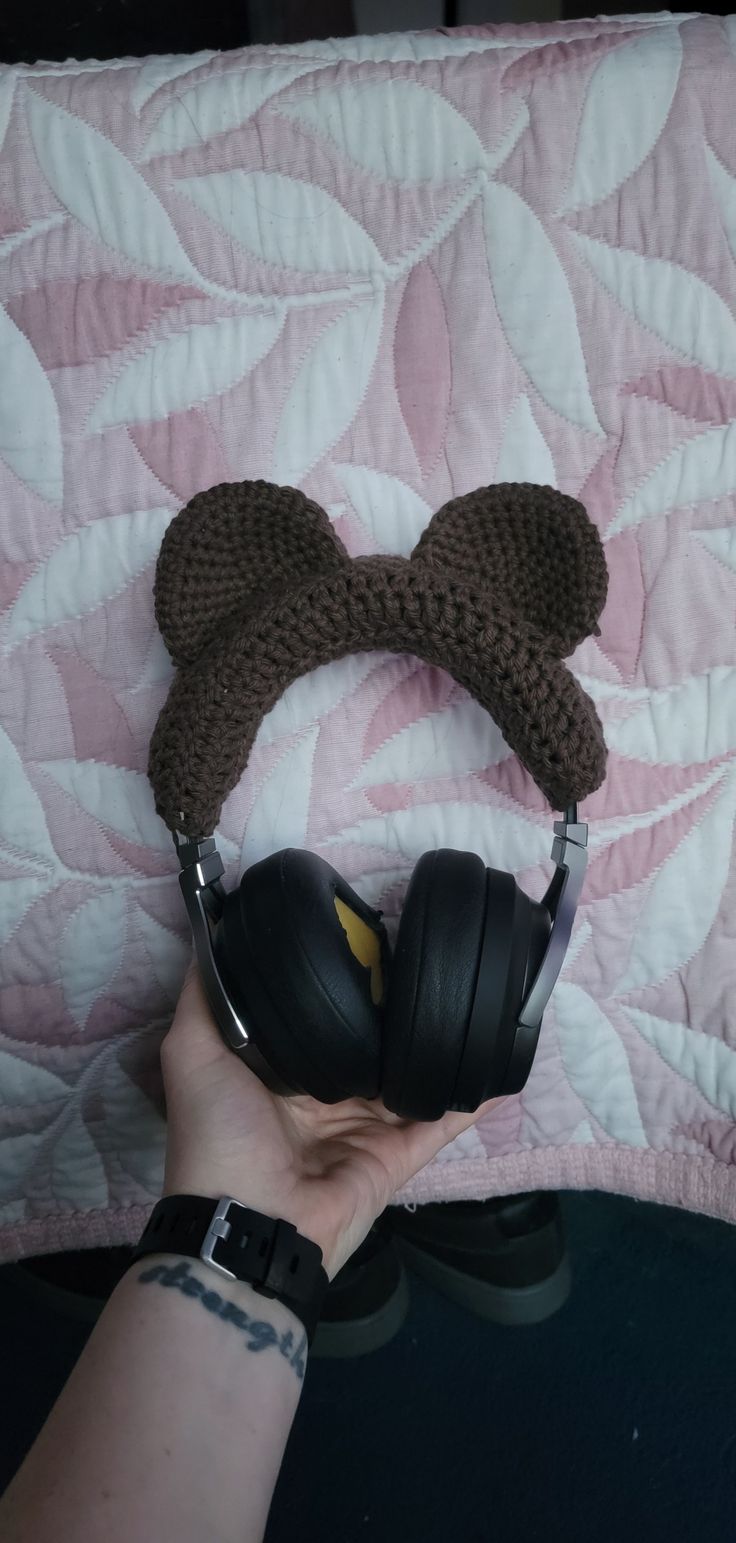 a person wearing ear muffs on top of a bed