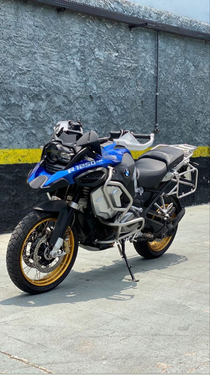 a blue and black motorcycle parked in front of a building