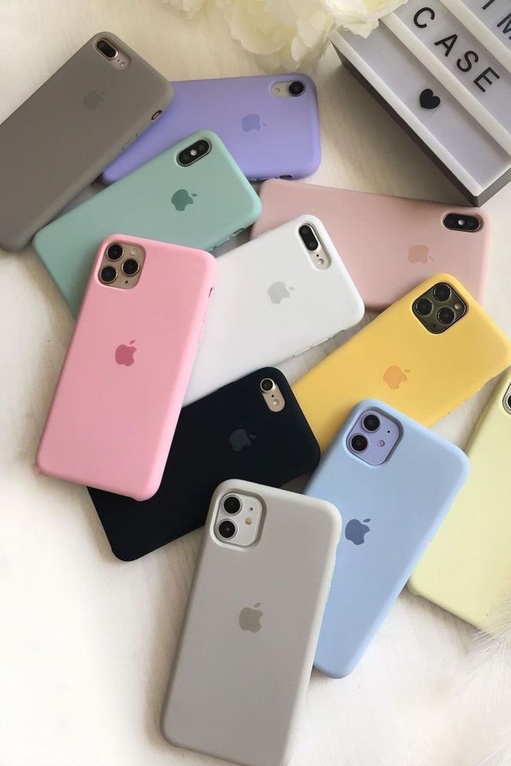 six iphone cases sitting next to each other on a white surface with flowers in the background