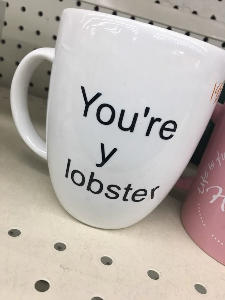 two coffee mugs with the words you're y lobster printed on them sitting next to each other