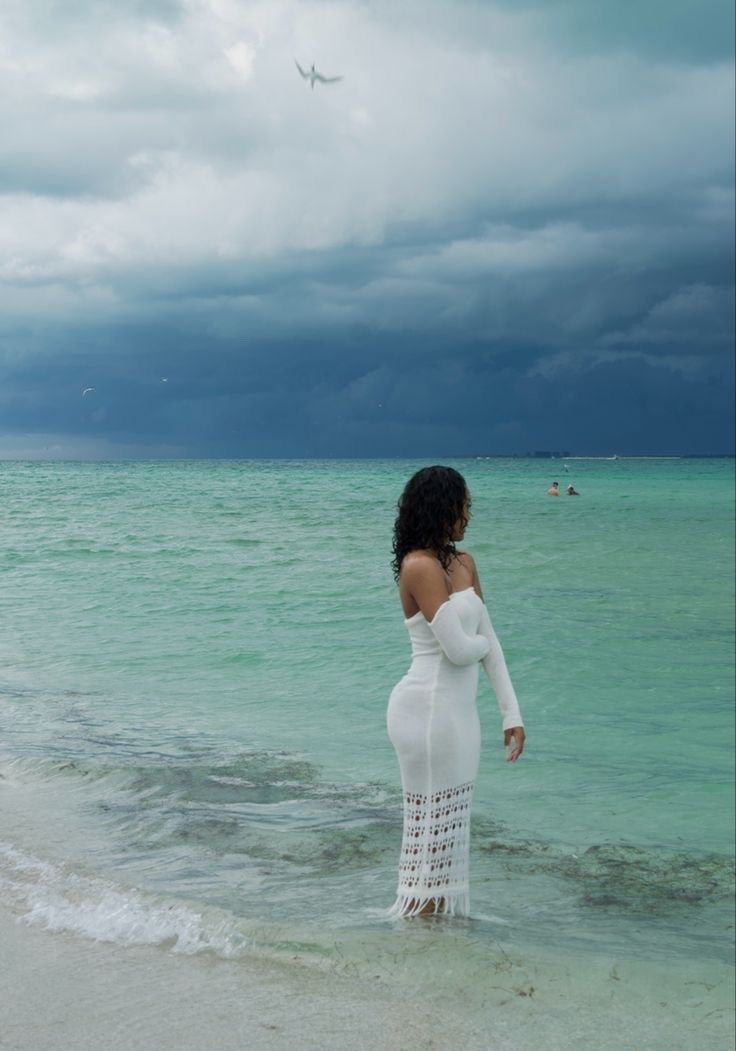 a woman standing in the water at the beach