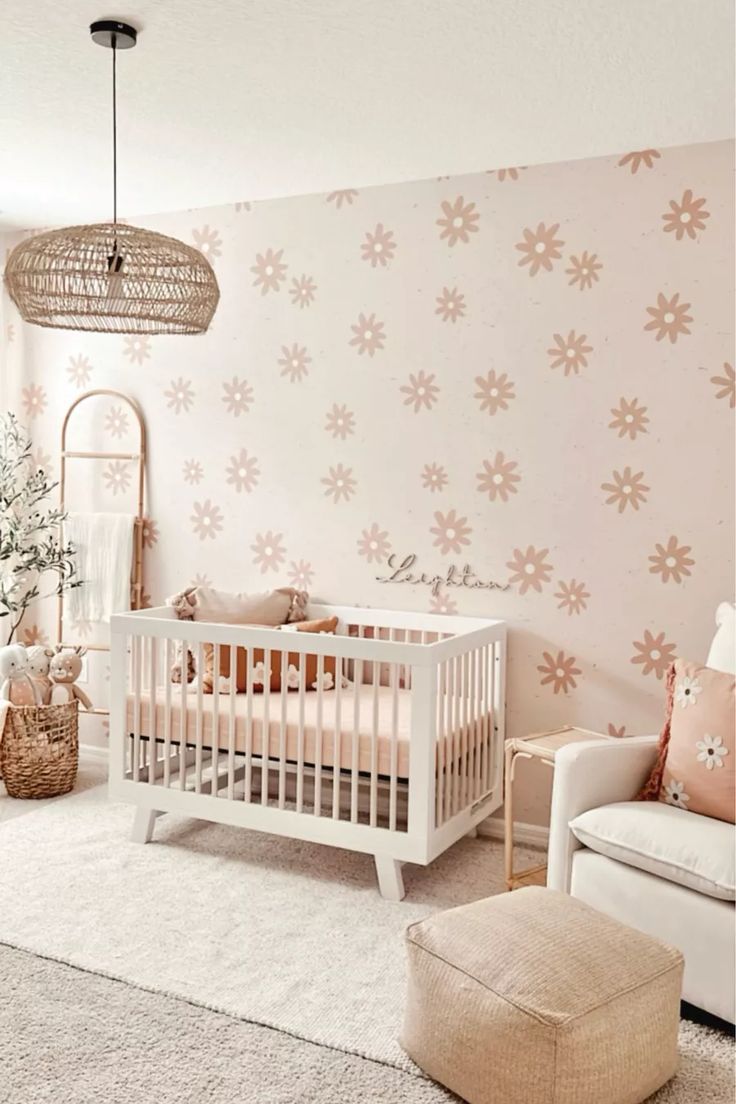 a baby's room decorated in pink and white with flowers painted on the wall