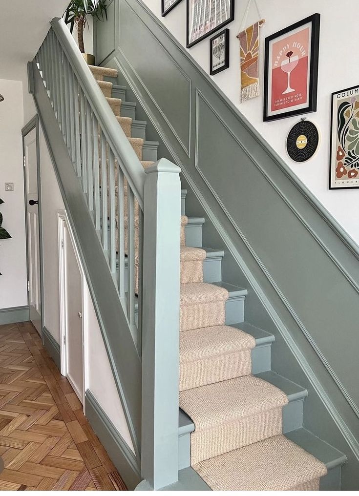 a staircase with pictures on the wall and carpeted stairs leading up to it's second floor