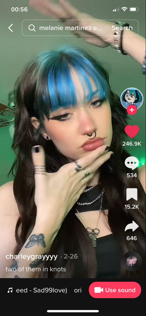 a girl with blue hair and piercings on her face