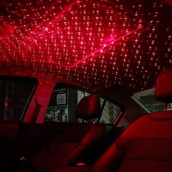 the interior of a car with red lights shining on it's walls and ceiling