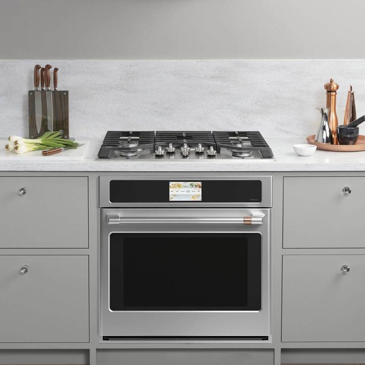 a stove top oven sitting inside of a kitchen next to counter tops and cupboards