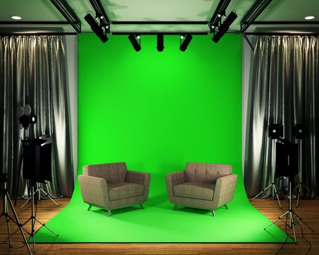 two chairs sitting in front of a green screen with lights on the floor and curtains behind them