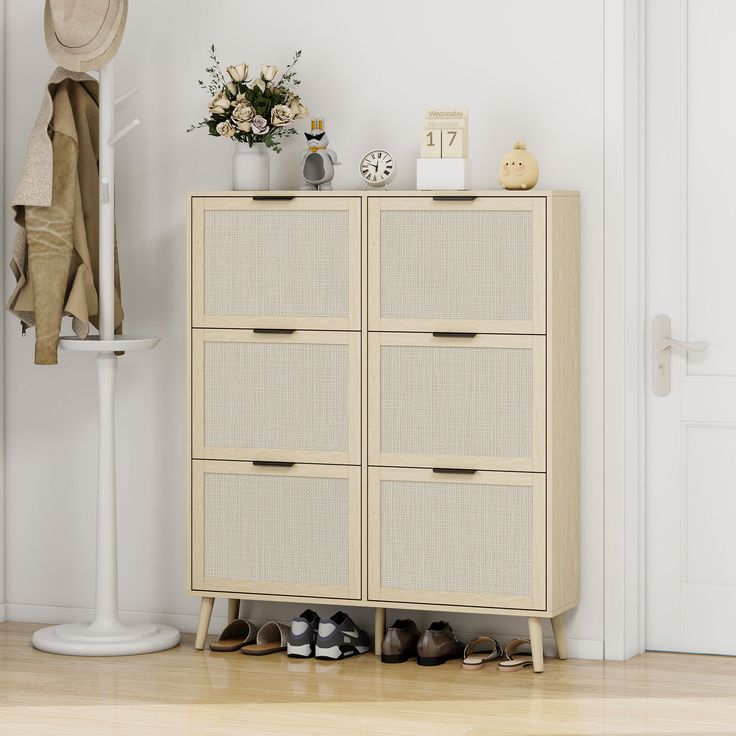 a white cabinet with shoes on it next to a hat rack and coat hanger