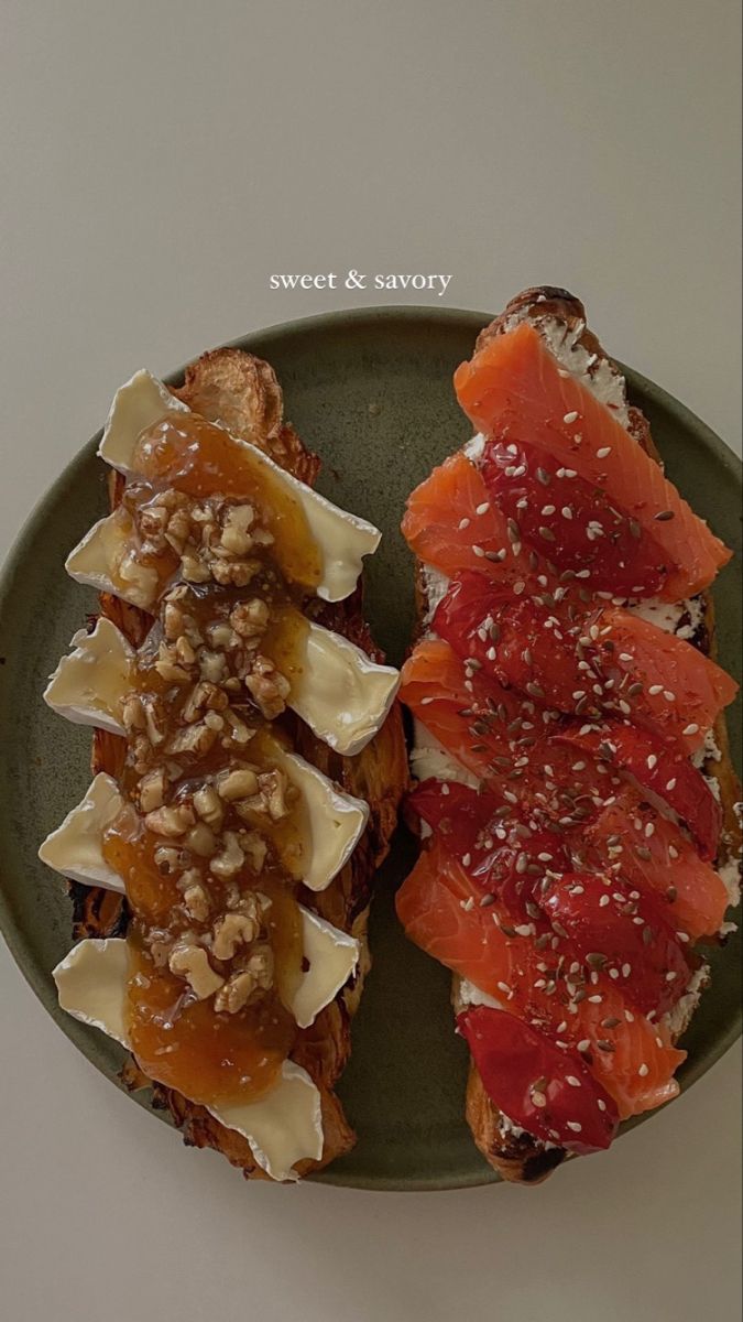 two pieces of toast with fruit and nuts on them, sitting on a green plate