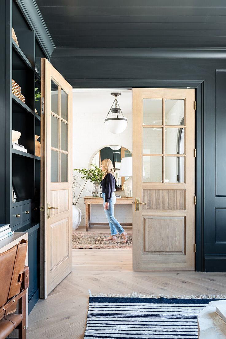 a woman is walking through an open door