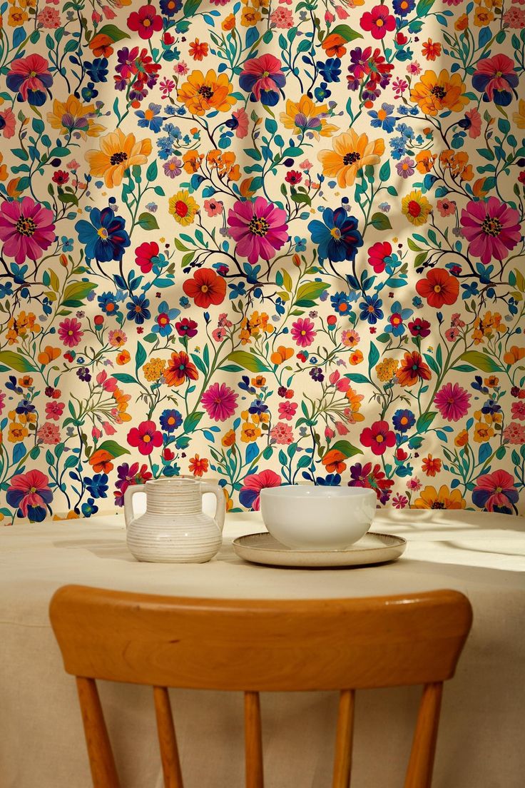 a table with two bowls on it in front of a floral wallpapered background