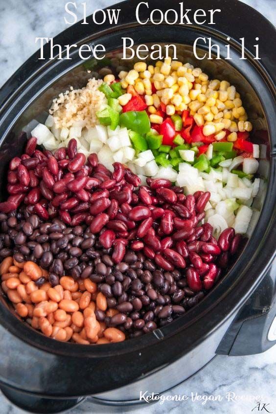 the slow cooker is filled with beans, corn, and other vegetables in it