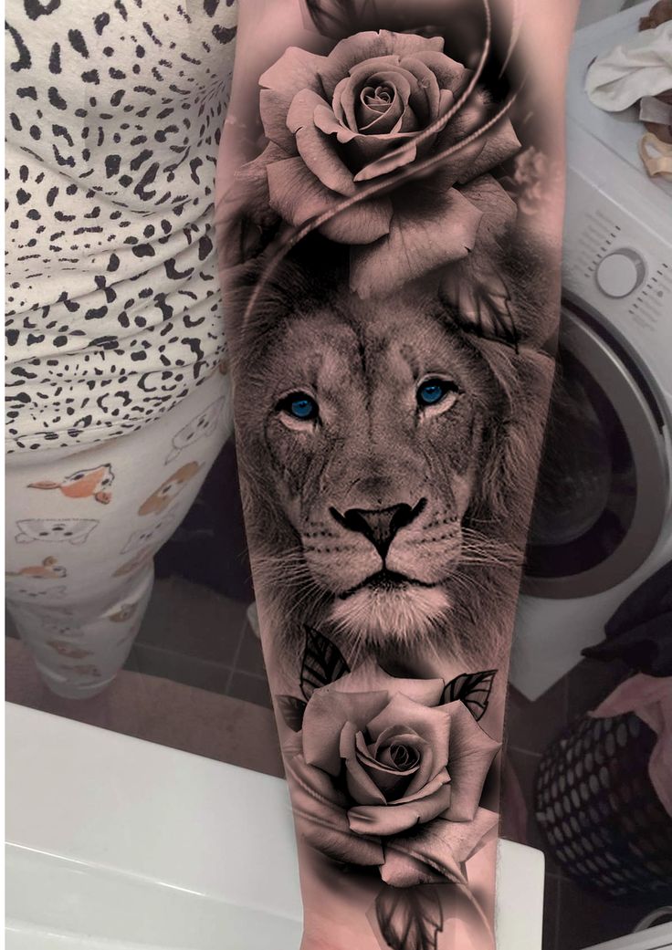 a lion with roses on his head and blue eyes is shown in this black and white tattoo