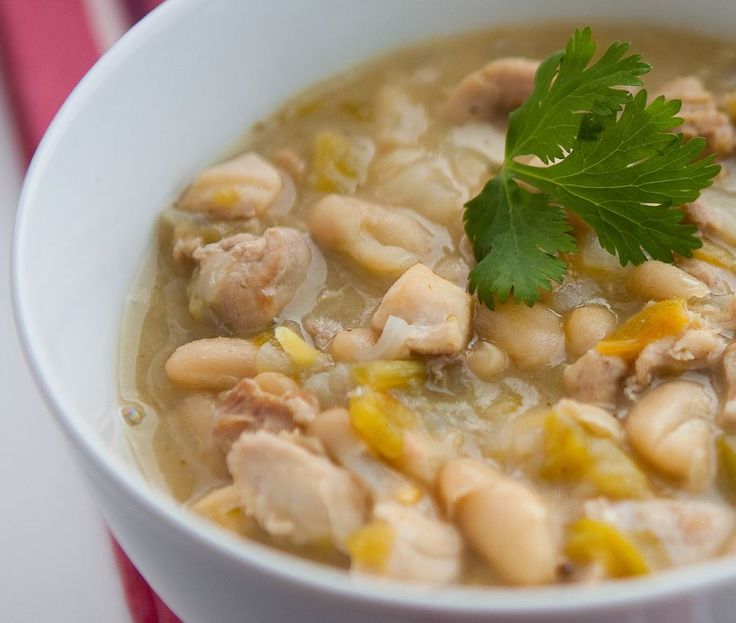 a white bowl filled with chicken and bean soup